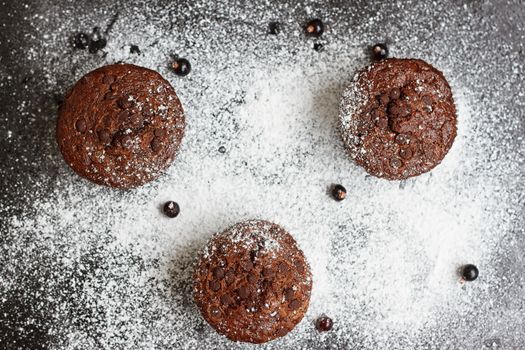 Chocolate cake on a black table with powdered sugar