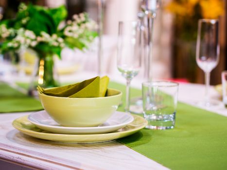 Beautiful table setting with white and green colors. Shallow DOF