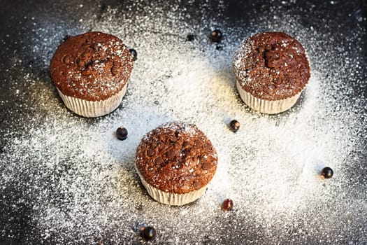 Chocolate cake on a black table with powdered sugar