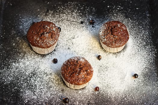 Chocolate cake on a black table with powdered sugar