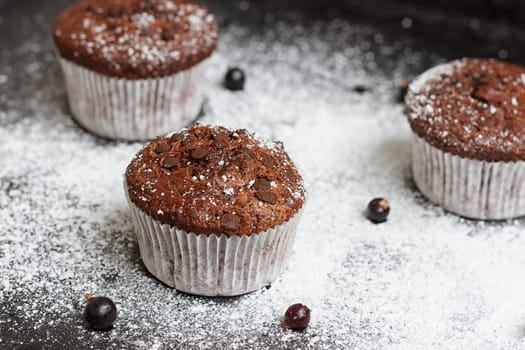 Chocolate cake on a black table with powdered sugar