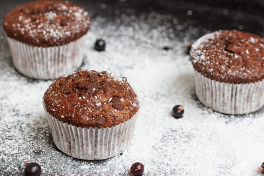 Chocolate cake on a black table with powdered sugar