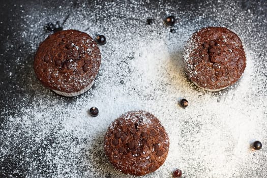 Chocolate cake on a black table with powdered sugar