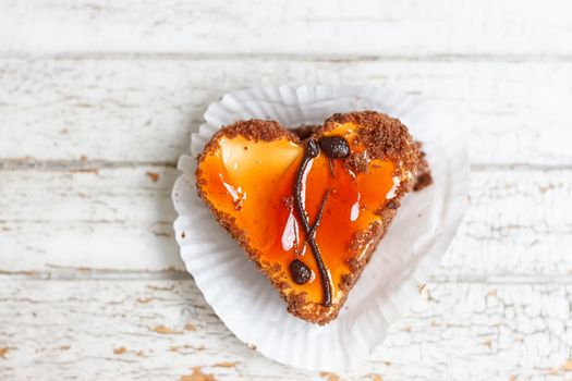 Coffee cake in the shape of a heart on a white wooden background