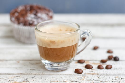 chocolate muffin and cup of coffee on the white wooden background