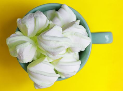 Peppermint large marshmallows in a large green cup on a yellow background