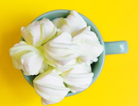 Peppermint large marshmallows in a large green cup on a yellow background