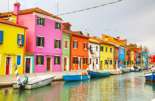 BURANO, ITALY - NOVEMBER 23: Brightly painted houses at the Burano canal on November 23, 2015 in Burano, Venice, Italy. It's an island in the Venetian Lagoon, northern Italy.