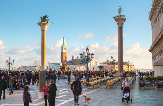 VENICE - NOVEMBER 22: San Marco square with tourists on November 22, 2015 in Venice, Italy. It's the principal public square of Venice, Italy, where it is generally known just as the Piazza.