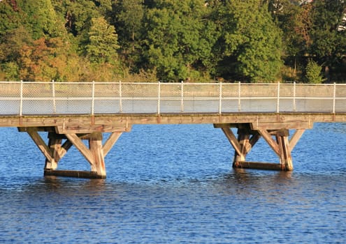 Low bridge over blue water with forest in background