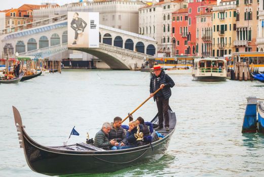 VENICE - NOVEMBER 22: Gondolas with tourists on November 22, 2015 in Venice, Italy. The gondola is a traditional, flat-bottomed Venetian rowing boat, well suited to the conditions of the Venetian lagoon.
