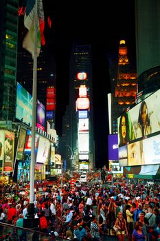 NEW YORK CITY - SEPTEMBER 05: Times square with people in the night on October 5, 2015 in New York City. It's major commercial intersection and neighborhood in Midtown Manhattan at the junction of Broadway and 7th Avenue.