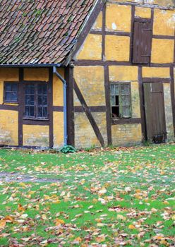Old worn half-timbered cottage house with broken window