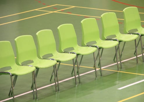 Line of green chairs in sports hall