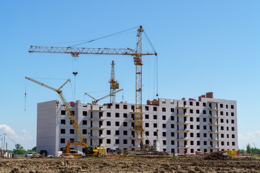 The construction of a multistory building. Construction cranes are on the building site