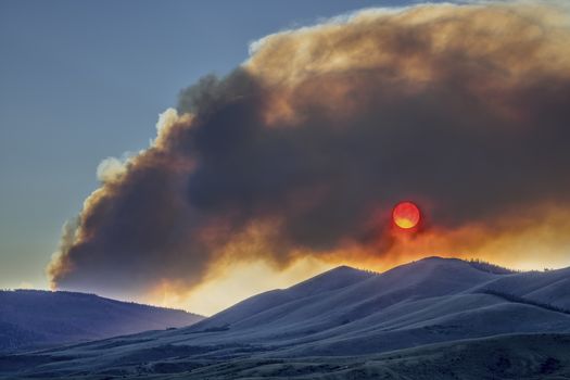 wildfire smoke plume obscuring sunset over mountains - North Park, Colorado