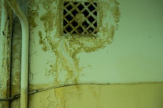 old ventilating lattice and two pipes on the wall with dirty streaked.
