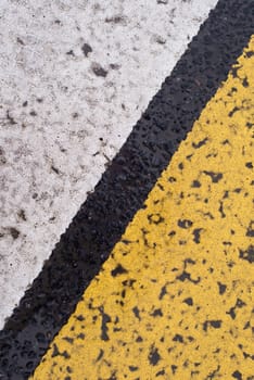 Asphalt highway texture with cracked white and yellow stripe.