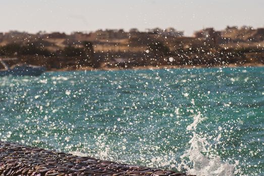 Photo closeup of beautiful clear turquoise sea ocean water surface with ripples and bright splash on seascape background, horizontal picture.