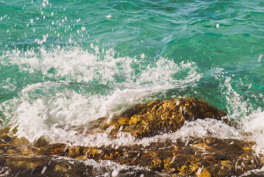 Photo closeup of beautiful clear turquoise sea ocean water surface with ripples and bright splash on seascape background, horizontal picture.