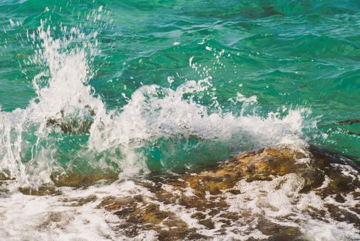 Photo closeup of beautiful clear turquoise sea ocean water surface with ripples and bright splash on seascape background, horizontal picture.