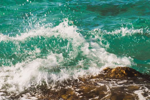 Photo closeup of beautiful clear turquoise sea ocean water surface with ripples and bright splash on seascape background, horizontal picture.