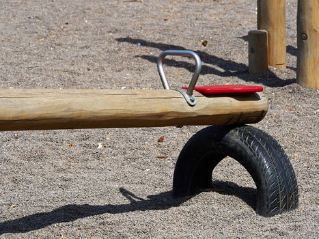 Seesaw teeter totter made in wood and metal in a playground
