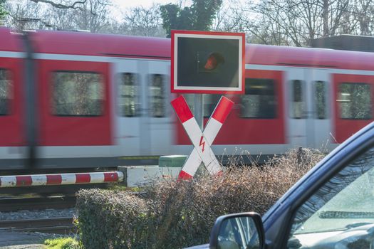 Waiting at a railroad crossing while a fast passenger train drives past. Intentional motion blur.