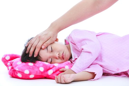 Mother checking temperature of sick daughter by hand. Adorable asian child in pink pajamas sleeping peacefully, isolated on white background.