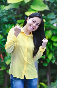 Asian woman smiling happy in park. Pretty young woman outdoors. Positive human emotion. Action of winner or successful people.