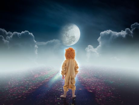 Back view of child costumed like a lion on pathway with a nightly sky and a large moon for halloween background. The moon taken with my own camera, no NASA images used.