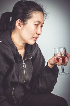 Side view of  asian woman with alcohol. Concept about human don't care for health. Vignette and vintage picture style.
