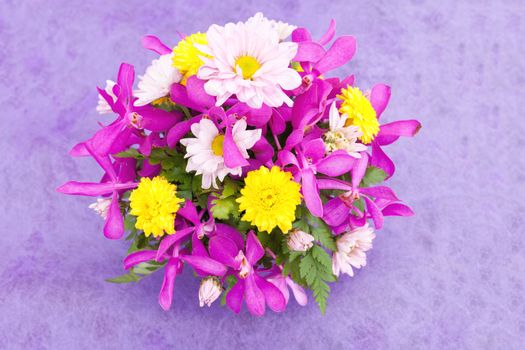 Bouquet of chrysanthemum and orchid flowers isolated on purple violet background.