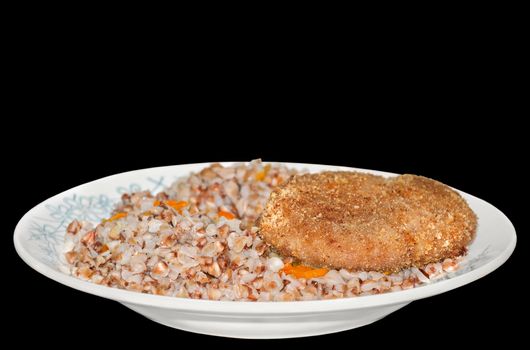 Buckwheat porridge with meat Patty on the plate, isolated on black background