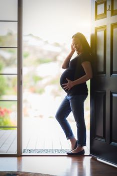 Happy Chinese Pregnant Woman Standing in Doorway.