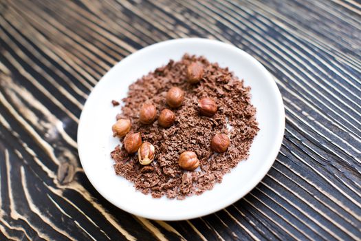 Grated chocolate and nuts on a white plate