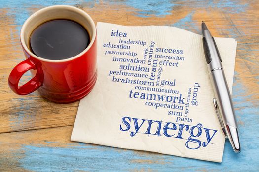 synergy and teamwork word cloud - handwriting on a napkin with a cup of coffee