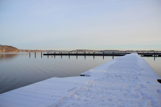 Cold winter lake with snow on swimming pier