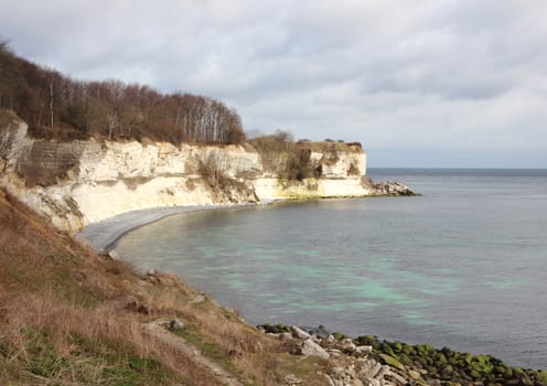 Stevns Klint Coastline with dark Sea and White Cliff and Reflections from Limestone Clay