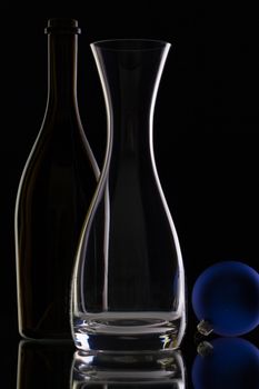 The bottle of wine,glass carafe and Christmas decoration on a black glass desk