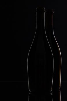 Two different bottles of wine on the black background