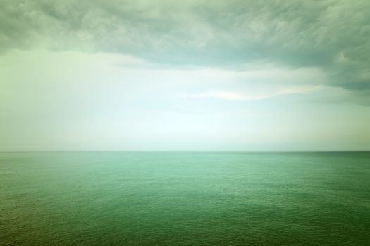 Moody green sea and clouds. Retro style image.