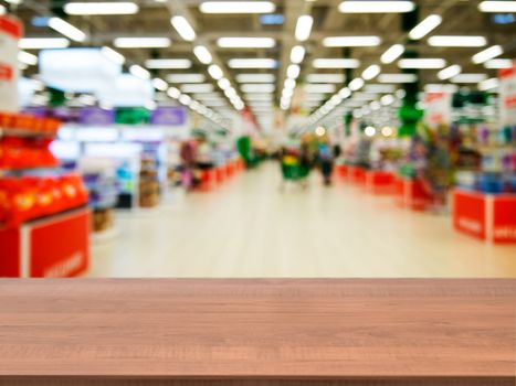 Wooden board empty table in front of blurred background. Perspective dark wood over blur in supermarket - can be used for display or montage your products. Mock up for display of product.