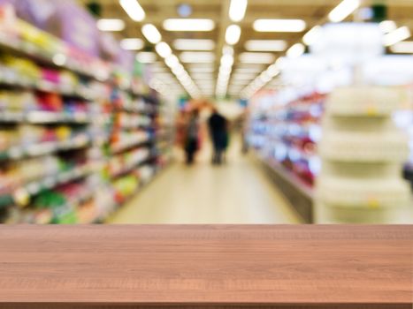 Wooden board empty table in front of blurred background. Perspective dark wood over blur in supermarket - can be used for display or montage your products. Mock up for display of product.