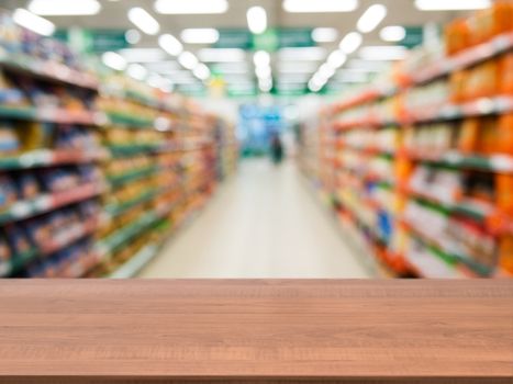 Wooden board empty table in front of blurred background. Perspective dark wood over blur in supermarket - can be used for display or montage your products. Mock up for display of product.