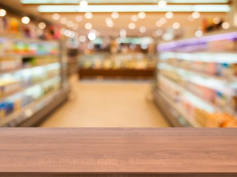 Wooden board empty table in front of blurred background. Perspective dark wood over blur in supermarket - can be used for display or montage your products. Mock up for display of product.