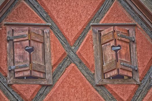 two wooden windows and red wall