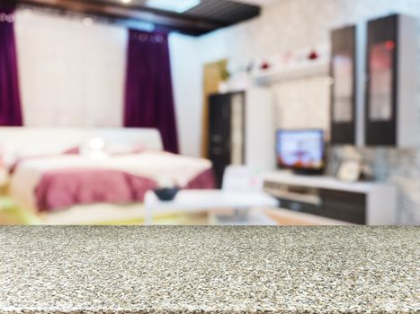 Marble board empty table in front of blurred background. Perspective marble board over blur in modern comfortable bedroom with beige bed