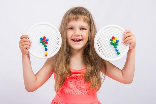 Girl shows colorful flowers collected from the mosaic