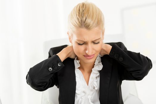 Young tired businesswoman holding hands on the neck with a pained expression on her face.